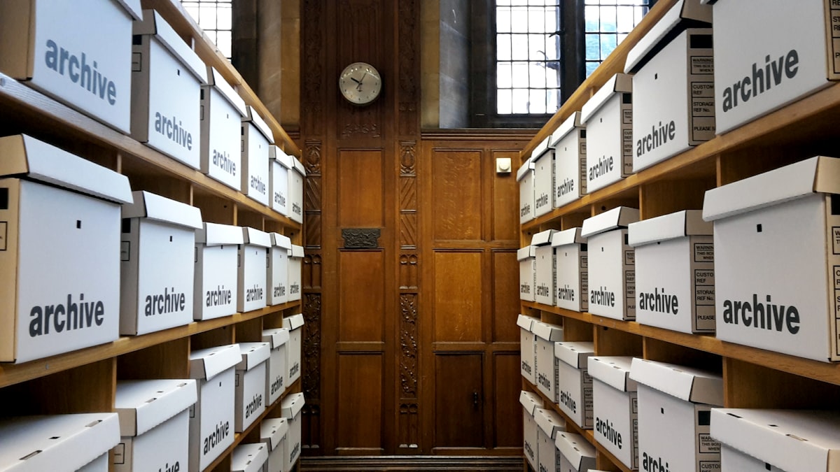 Rows of labeled archive boxes on shelving in a records room