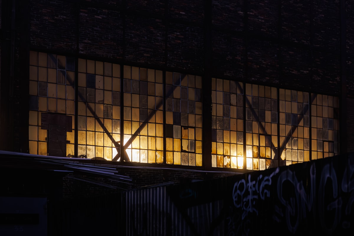 Exterior of an industrial warehouse lit from within at night